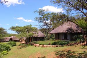 a couple of huts with a grass roof at Ascot Bush Lodge in Pietermaritzburg