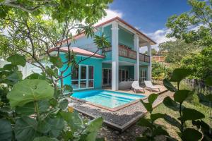 une maison avec une piscine en face de celle-ci dans l'établissement Les Villas du Lagon, au François