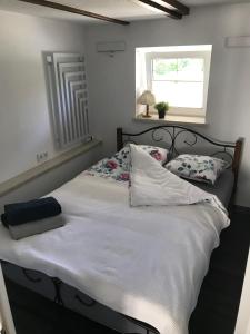 Una cama con sábanas blancas y almohadas en un dormitorio en Skalny ogród, en Szczytna