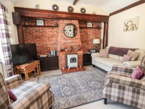 a living room with a fireplace and a brick wall at Ty Cerrig in Rhyl