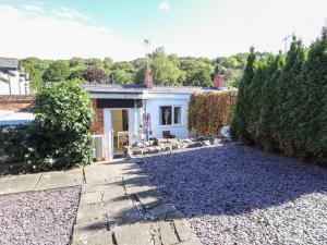 a house with a yard with a gravel driveway at Ty Cerrig in Rhyl