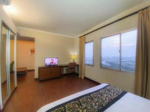 a hotel room with a bed and a desk and window at Ancol Marina Residence in Jakarta