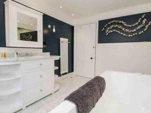 a white bathroom with a sink and a mirror at Bank Chambers in Bowness with Hot Tub and Lake Access in Bowness-on-Windermere +45 photos