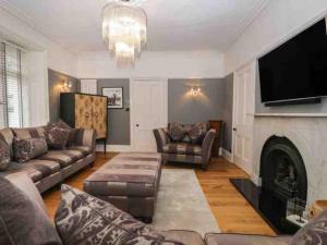 a living room with a couch and a fireplace at Bank Chambers in Bowness with Hot Tub and Lake Access in Bowness-on-Windermere