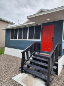 a blue house with a red door and stairs at Lovely One Bedroom home/ guest house in Lakeland