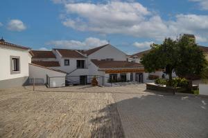 a group of white houses with a tree in a courtyard at C`Alma D`Alentejo in Alandroal