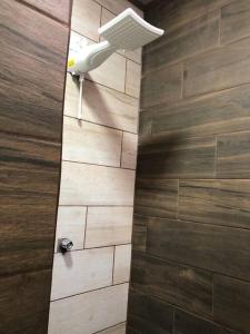 eine Dusche im Bad mit einer Holzwand in der Unterkunft Departamento H González 2 in El Coco