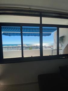 a window with a view of the beach through it at Hilo Verde in Matalascañas