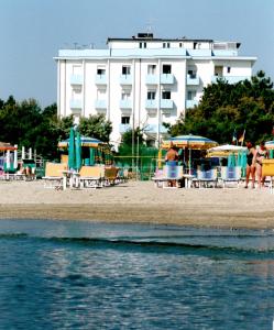 um hotel na praia com cadeiras e guarda-sóis em Hotel Mirage em Lido di Classe