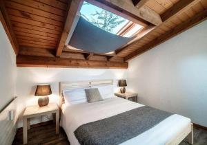 um quarto com uma cama grande e uma clarabóia em Casa Rogoria - Intimo rifugio con terrazza e caminetto em Astano