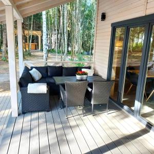 patio con divano e sedie su una terrazza di Świerkowisko cisza las plaża blisko a Ostróda