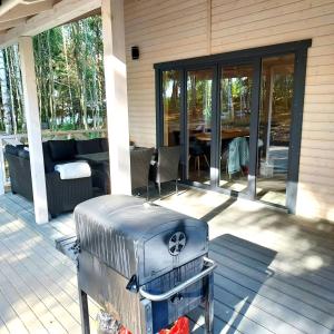 un porche cubierto con una parrilla en el patio en Świerkowisko cisza las plaża blisko en Ostróda