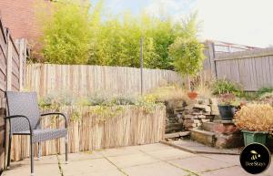 un patio con una silla y una valla en Bee Stays - Caldecott House, en Mánchester