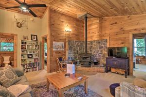 ein Wohnzimmer mit einem Kamin und einem Herd in der Unterkunft Rustic-Yet-Cozy Cabin with Fire Pit in Smokies! in Waynesville