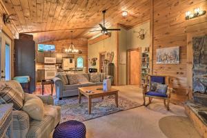 ein Wohnzimmer mit einem Sofa und einem Tisch in der Unterkunft Rustic-Yet-Cozy Cabin with Fire Pit in Smokies! in Waynesville