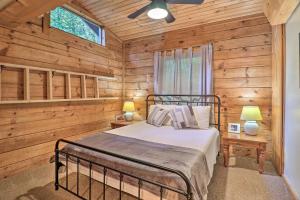 ein Schlafzimmer mit einem Bett in einem Blockhaus in der Unterkunft Rustic-Yet-Cozy Cabin with Fire Pit in Smokies! in Waynesville
