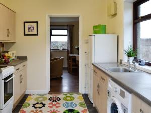 a kitchen with a sink and a refrigerator at Beuchan Bungalow in Closeburn