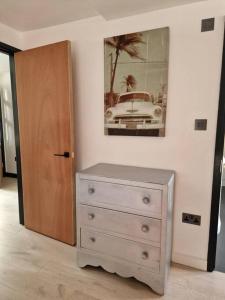 a bedroom with a dresser and a picture of a car at London Sky Home - stunning 3 bed apt in the Sky in London