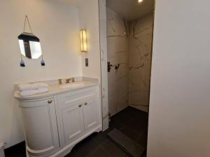 a bathroom with a white sink and a shower at London Sky Home - stunning 3 bed apt in the Sky in London