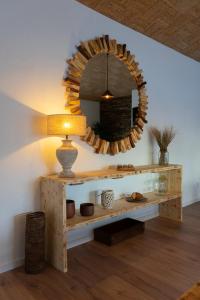 a table with a lamp and a mirror on a wall at C`Alma D`Alentejo in Alandroal