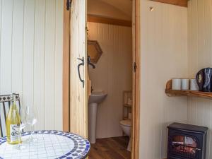 a small room with a table and a toilet at The Cider Pressers Hut-uk39773 in Trefeglwys