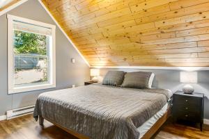 a bedroom with a bed and a wooden ceiling at Snowdrop Summit Cabin in Snoqualmie Pass