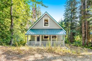 una pequeña casa con techo azul en el bosque en Snowdrop Summit Cabin, en Snoqualmie Pass