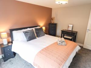 a bedroom with a bed and two night stands at Printers Cottage in Alford