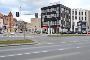 an empty city street with a traffic light and buildings at Office Park Aparthotel in Toruń