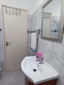 y baño con lavabo blanco y espejo. en Casa da Pedra, en Moledo