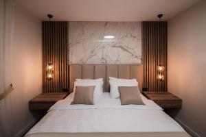 sypialnia z dużym białym łóżkiem z 2 poduszkami w obiekcie Villa Inverno & Spa w mieście Kolašin
