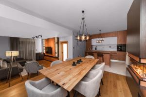 kuchnia i salon z drewnianym stołem i krzesłami w obiekcie Villa Inverno & Spa w mieście Kolašin