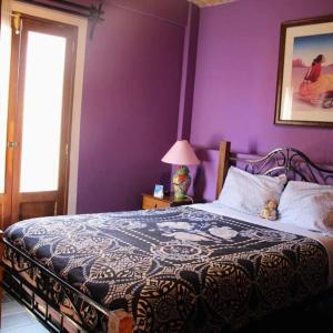 um quarto com uma cama com uma parede roxa em Casa Jardín em Guanajuato