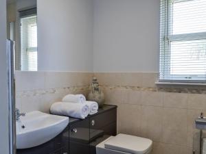 a bathroom with a sink and a toilet and a mirror at Queens View Lodge in Inchmarlo