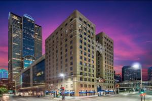 a tall building in a city at night at Hotel Indigo Dallas Downtown by IHG in Dallas