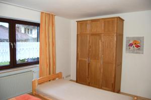 1 dormitorio con armario de madera junto a una ventana en Ferienwohnung Marketa en Bayerisch Eisenstein