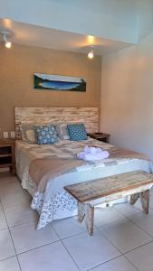 1 dormitorio con 1 cama grande y cabecero de madera en Casa da Aroeira, en Búzios