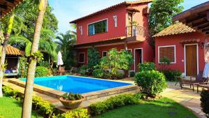 uma villa com piscina em frente a uma casa em Pousada Casa da Aroeira em Búzios