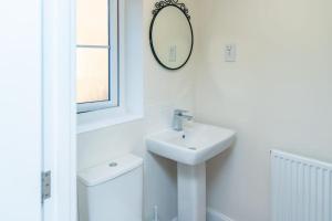 a white bathroom with a sink and a mirror at Cozy 3 bed Sasha house in Beeston Nottingham in Nottingham