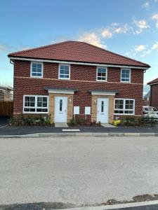 a red brick house with white doors on a street at Cozy 3 bed Sasha house in Beeston Nottingham in Nottingham