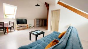 a living room with a blue couch and a tv at Apartmán pre 5 osôb, 2 spálne, Banská Bystrica Podlavice 24h self checkin in Banská Bystrica