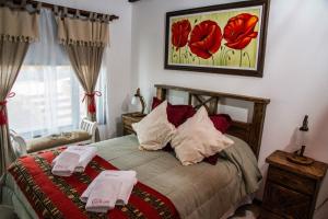 1 dormitorio con 1 cama con 2 toallas en Luz de Luna Cabañas en El Calafate