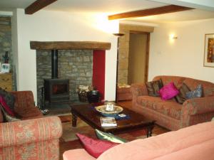 a living room with two couches and a fireplace at Foxhill Barn in Gisburn