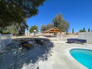 eine Terrasse mit Stühlen und einen Pool mit Pavillon in der Unterkunft Kern River Home in Bakersfield