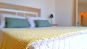 zbliżenie łóżka z żółtym kocem w obiekcie Ático Deluxe Granada, Parking gratis y Terraza w mieście Armilla