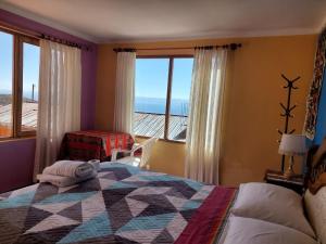 a bedroom with a bed and a view of the ocean at Hostal Tawri in Isla de Sol