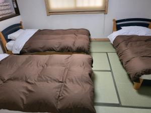 two beds sitting next to each other in a room at Hakuba Inn Bloom - Vacation STAY 95727 in Hakuba