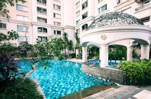 a swimming pool with a gazebo in front of a building at Ancol Marina Residence in Jakarta