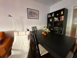 einen schwarzen Tisch und Stühle im Wohnzimmer in der Unterkunft Mike´s apartment. Parking y piscina in Granada
