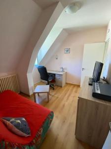 Zimmer mit einem Bett und einem Schreibtisch mit einem Computer in der Unterkunft Appartement 4-6 personnes calme proche centre-ville SLT in La Bourboule
